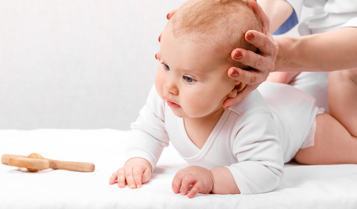 Little baby receiving osteopathic treatment of head and neck